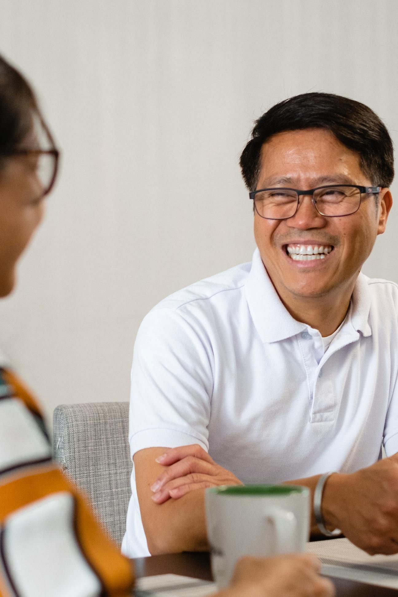 Man smiling and drinking coffee with a friend (portrait)