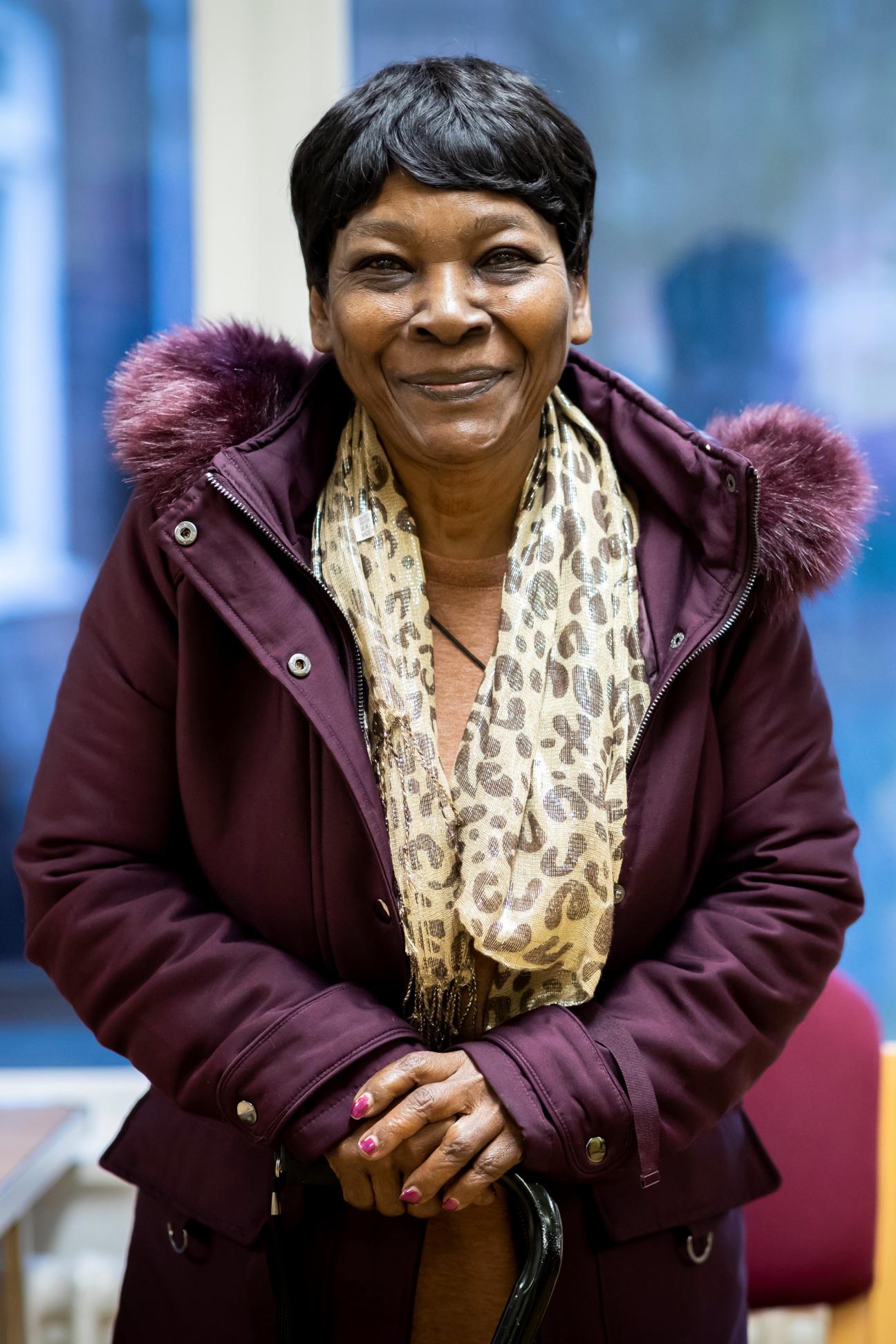 Older woman smiling in a purple coat