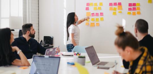 People working around a table and whiteboard