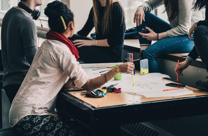 SITUATE group of young people working at a desk