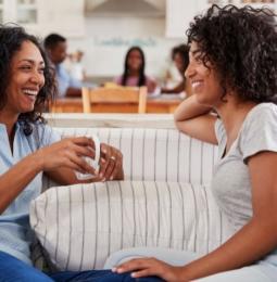 Two women sat on a sofa talking together