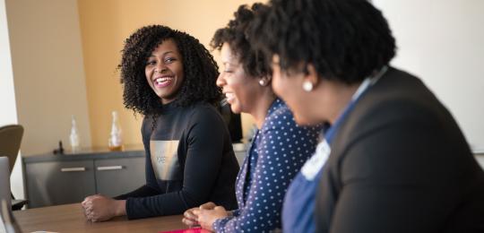 Women in a meeting room smiling