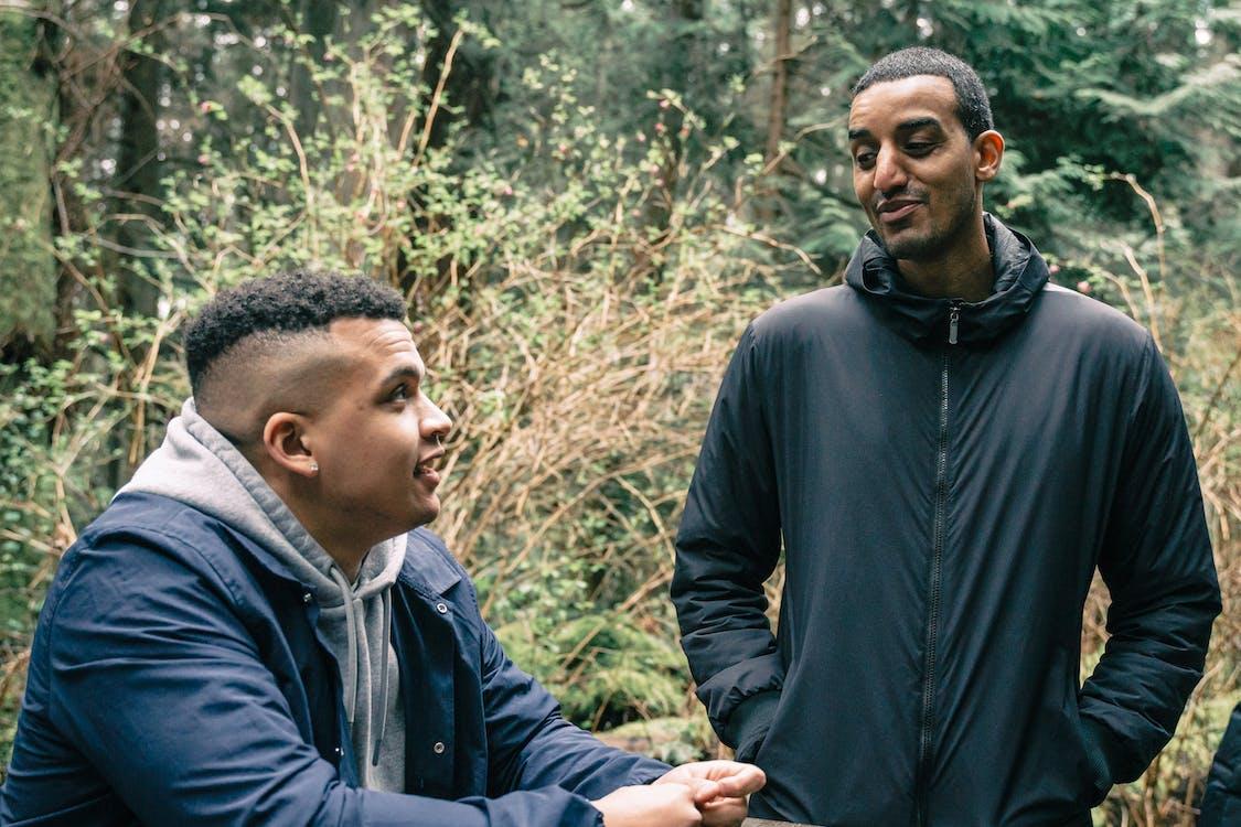 Two young men talking, out in nature
