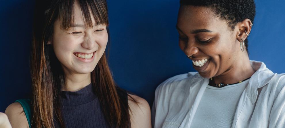 Young people laughing and looking at a notebook