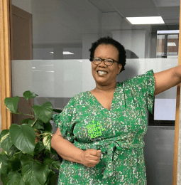 A photo of a smiling Menesia, wearing green for Wear It Green Day
