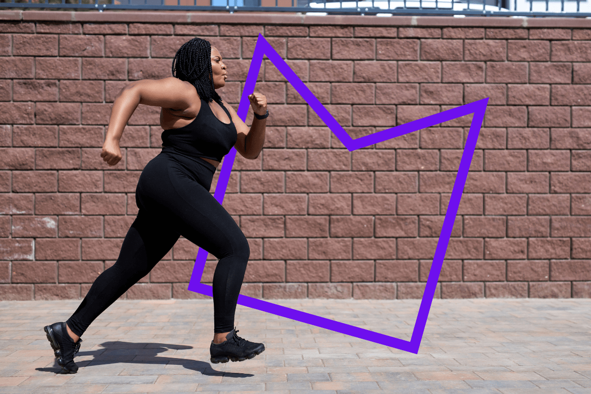 A woman running in front of a brick wall