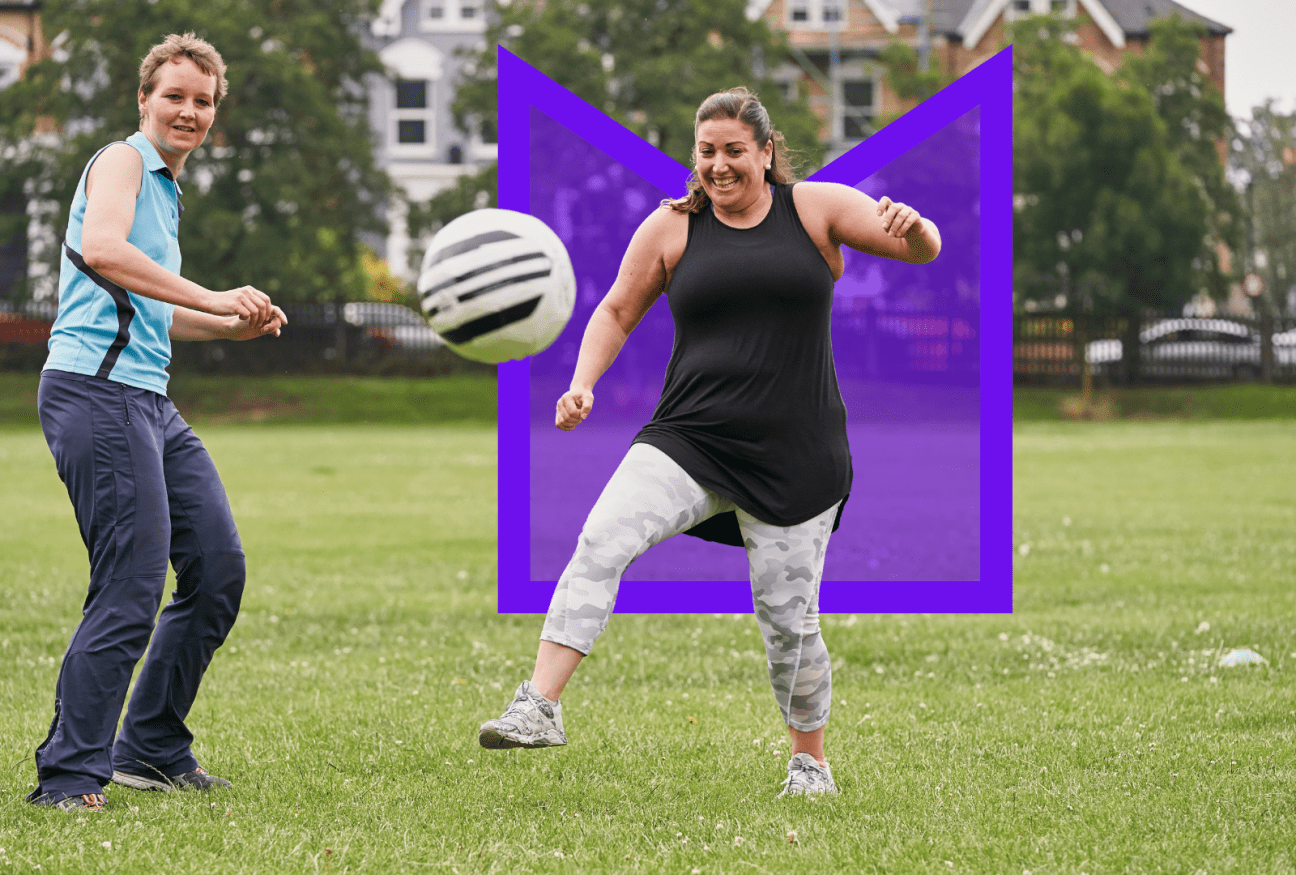 Two people playing football in the park